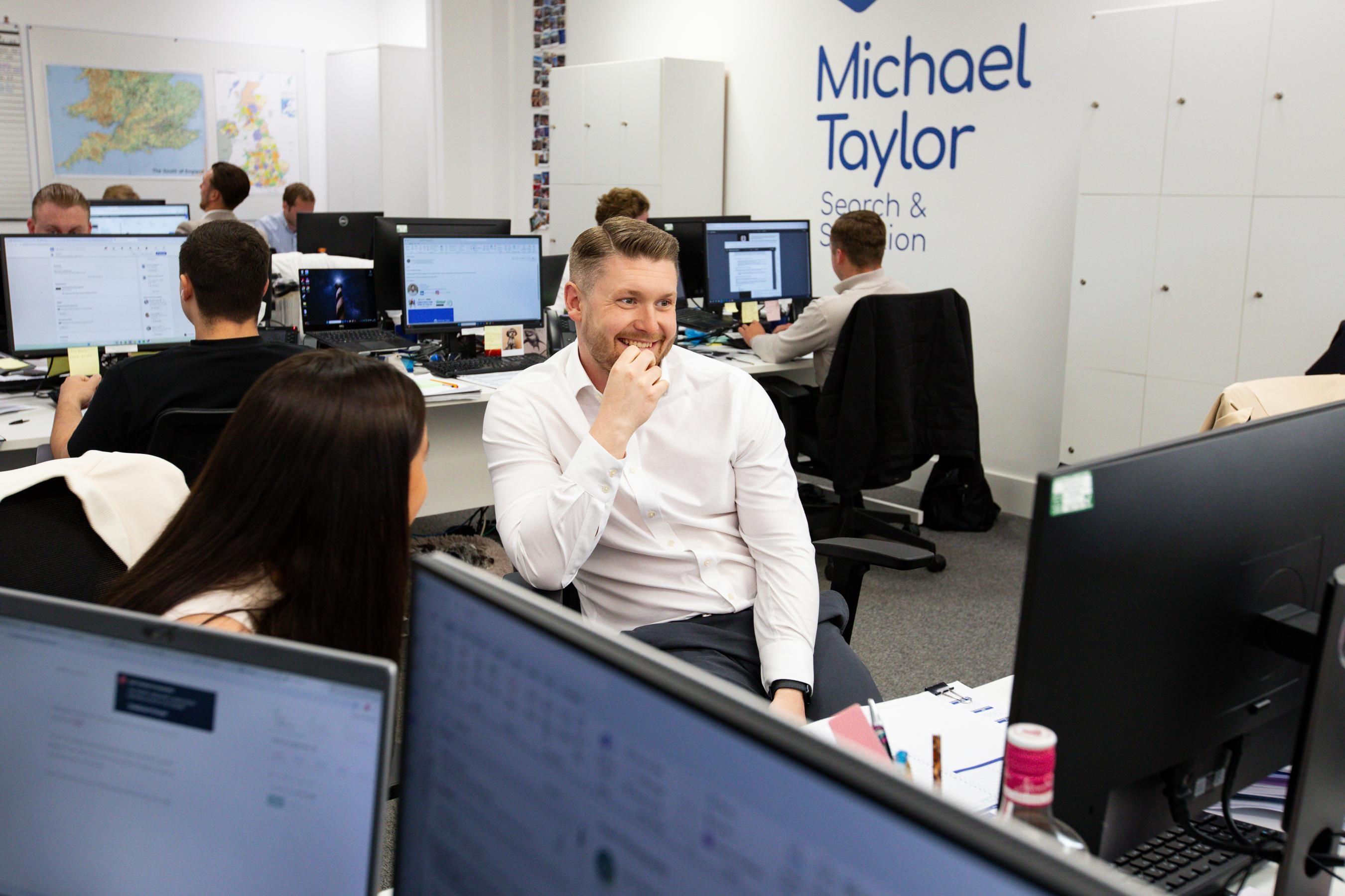 An office environment with a man smiling