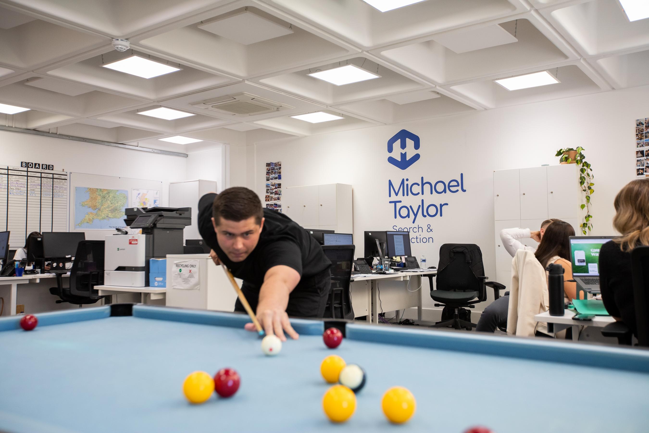 Man playing pool in an office
